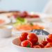 Close-up shot of vibrant cherry tomatoes in a bowl on a well-set dining table.
